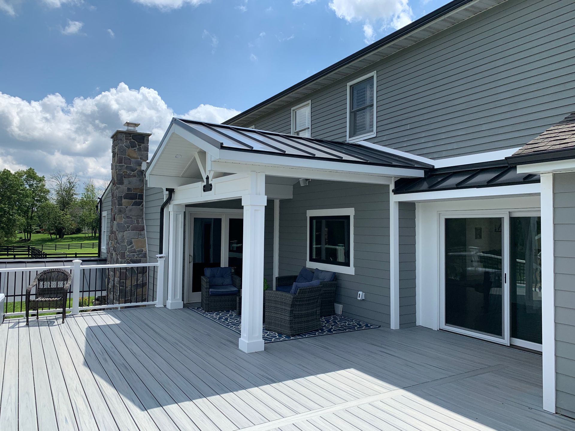 Composite Deck project in Newtown, PA — Covered composite deck with metal-roof pavilion and stone fireplace